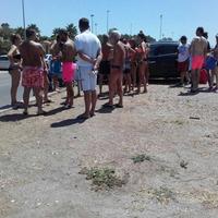 I bagnanti che hanno scoperto lo straniero fotografare i minori sulla spiaggia